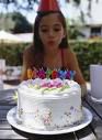 girl blowing candles on birthday cake
